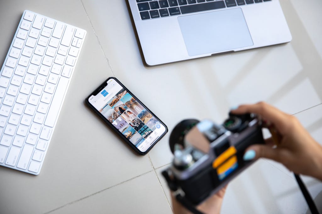 Photo by Plann Person using vintage camera with smartphone and laptop in creative setup.