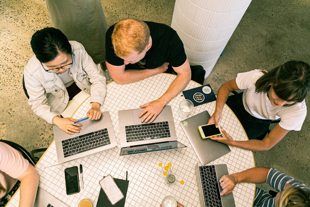 Photo by Canva Studio Top view of diverse team collaboratively working in a modern office setting.
