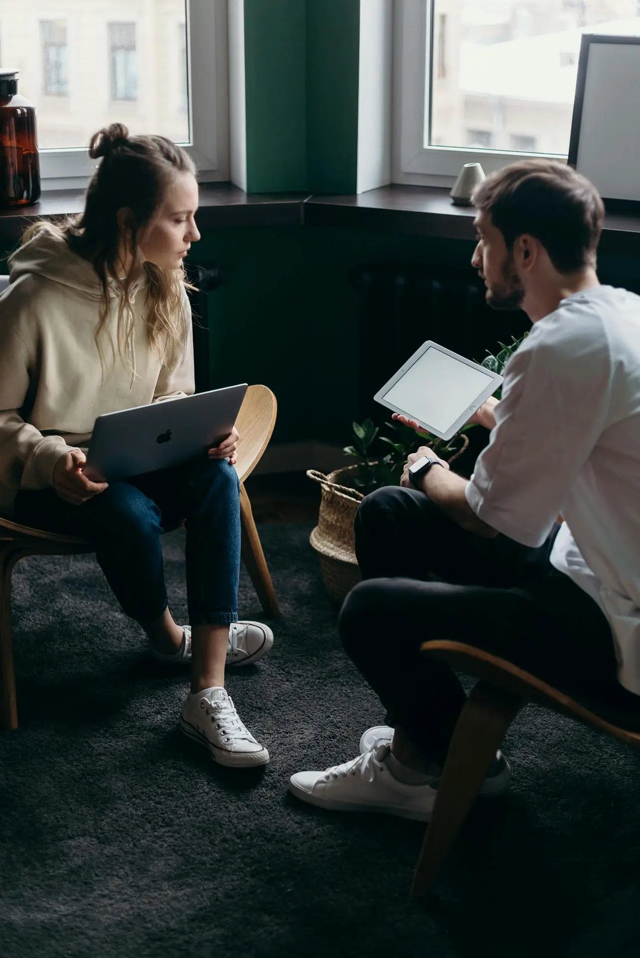 Photo by cottonbro studio Two adults having a tech-focused discussion in a cozy home setting.
